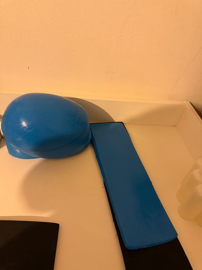 Support en caoutchouc incurvé pour l'injection de mèches de cheveux sur une micro-peau en vue de la fabrication de prothèses capillaires.